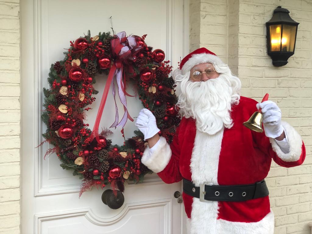 LE PÈRE NOËL devant une porte décorée