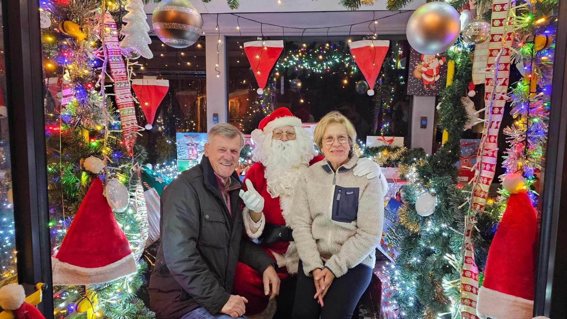 LE PÈRE NOËL avec un couple dans un décor illuminé